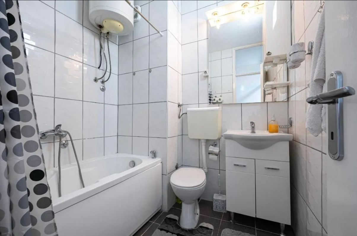Small bathroom with a bathtub, sink, and toilet.