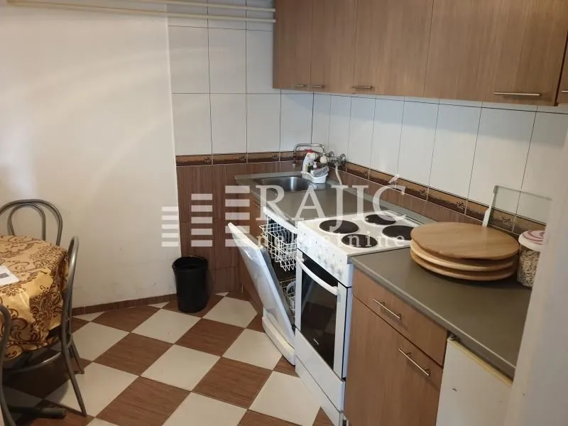 Smaller kitchen with wooden cabinets and a dining table.