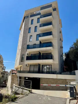 Exterior view of a modern multi-story building with balconies and ground-floor parking. - image 14