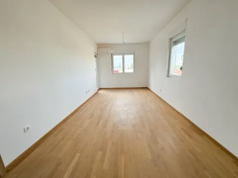 Prazna neopremljena prostorija sa bijelim zidovima i drvenim podom. - image 3