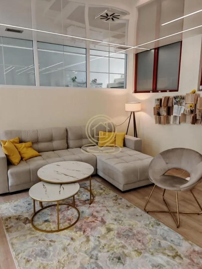 Living room with a corner sofa, coffee tables, and an armchair.