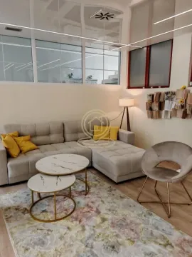Living room with a corner sofa, coffee tables, and an armchair. - image 6