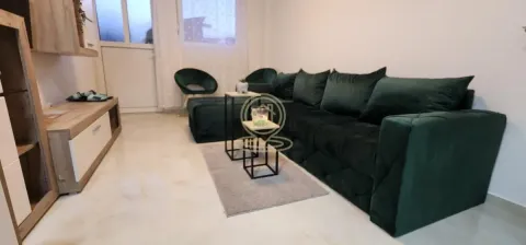 Dnevna soba sa zelenom sofom, klub stočićem i TV komodom. - image 9
