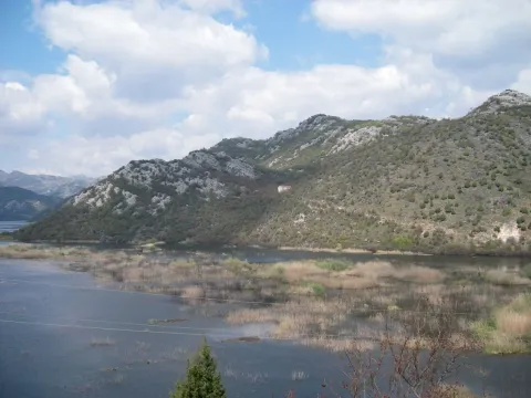 Pogled na jezero i brda pod djelimično oblačnim nebom. - image 3
