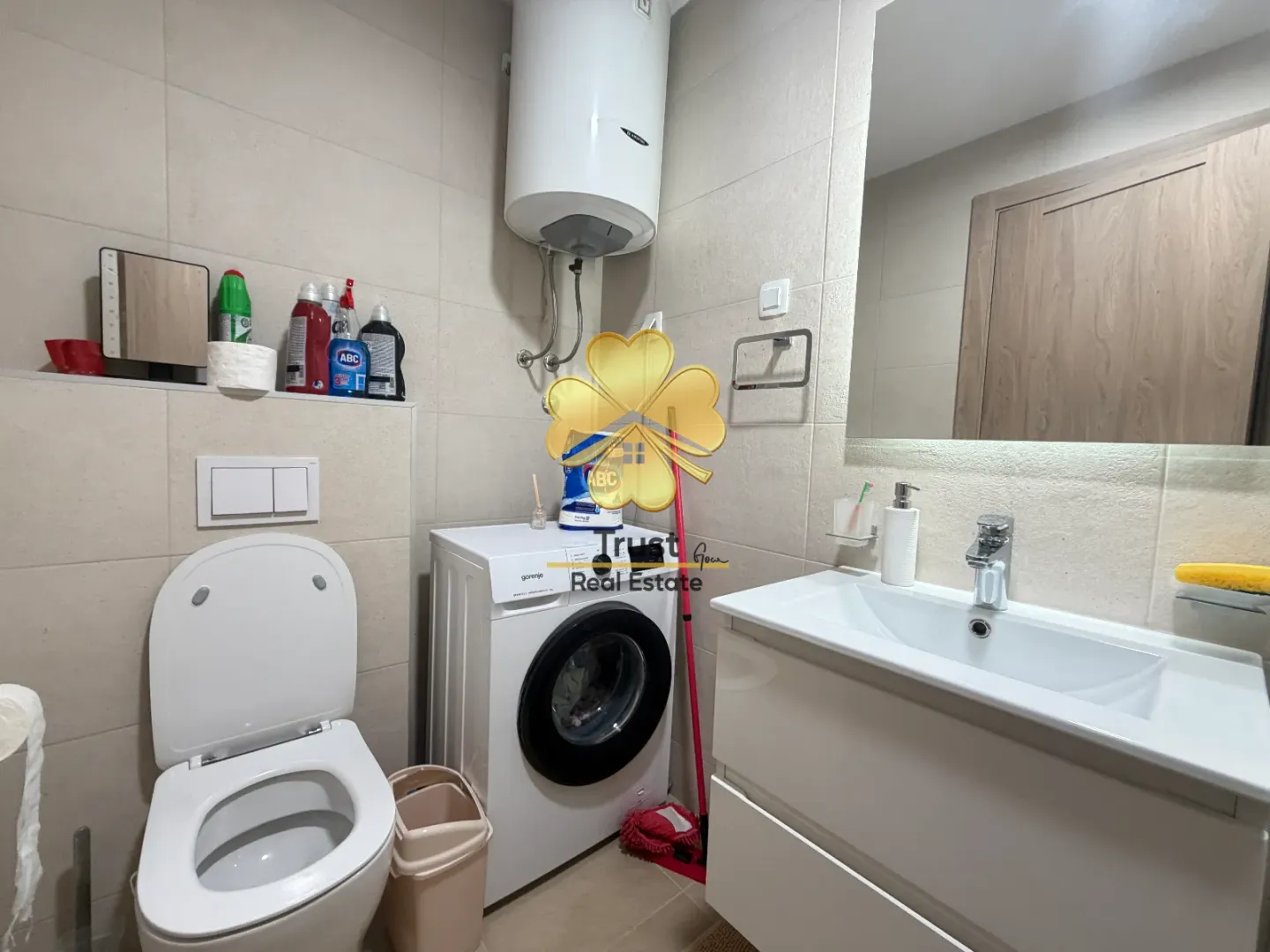 Moderno opremljeno kupatilo sa WC šoljom, umivaonikom, veš mašinom i bojlerom.