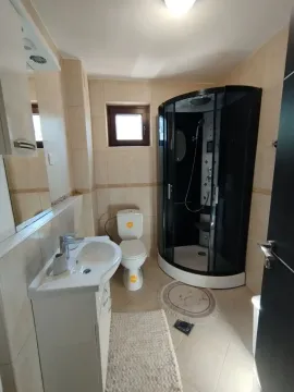 Small bathroom with a shower cabin, washbasin, and toilet. - image 8