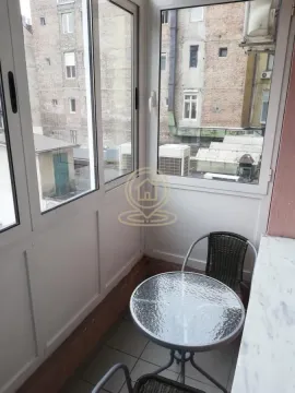 Zastakljeni balkon sa malim stolom i stolicama. - image 4