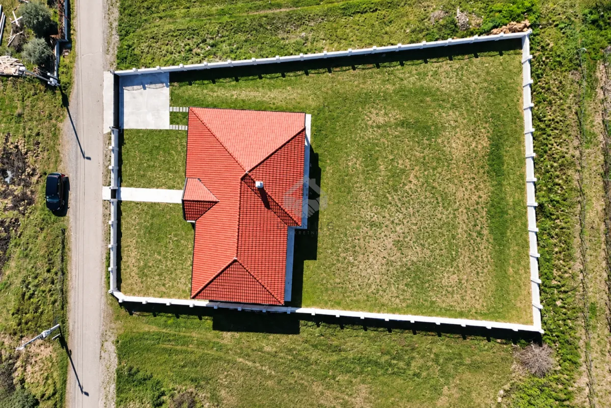 Aerial view of the house with a yard and fence.