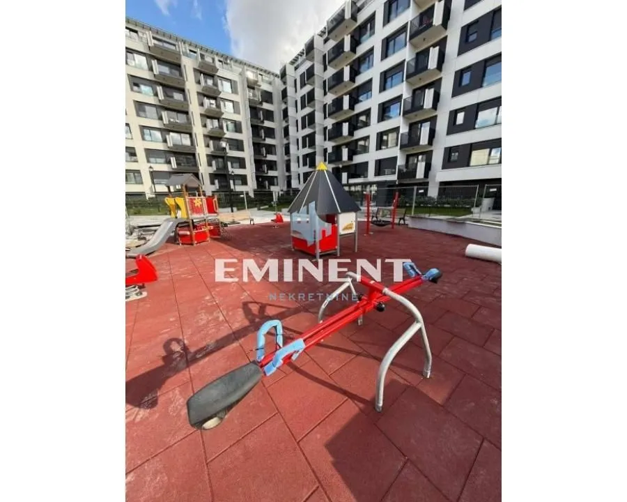 Children's playground with equipment in front of a modern residential building.