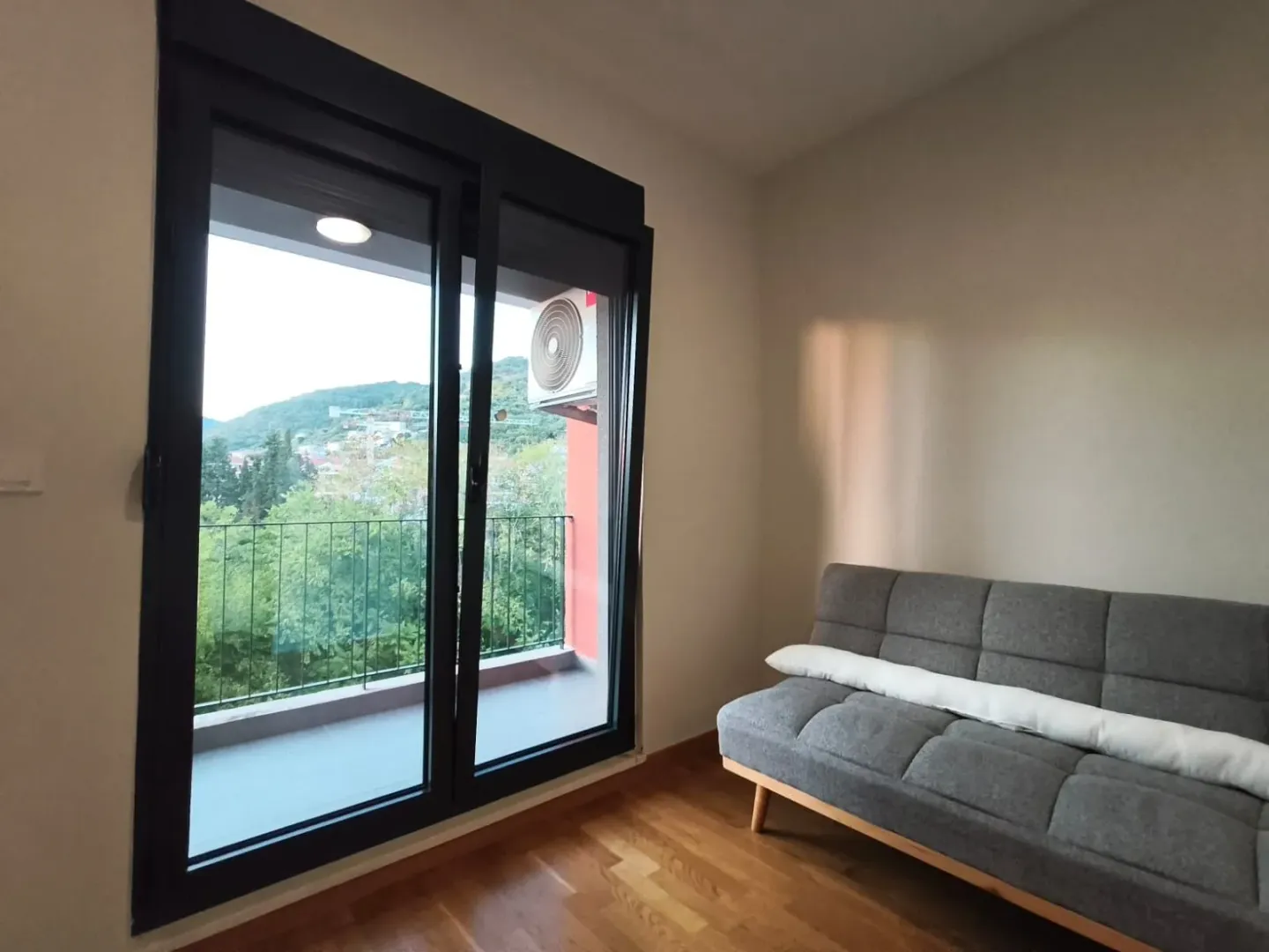 Living room with a grey sofa and access to the terrace.