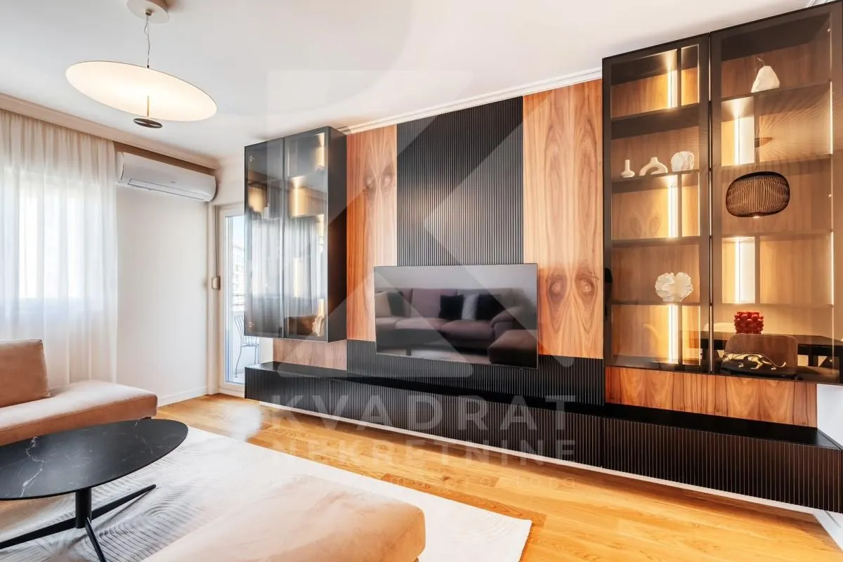 Living room with modern furniture and a TV wall unit with display cabinets.
