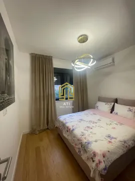 Furnished bedroom with a double bed, wooden flooring, and modern lighting. - image 11