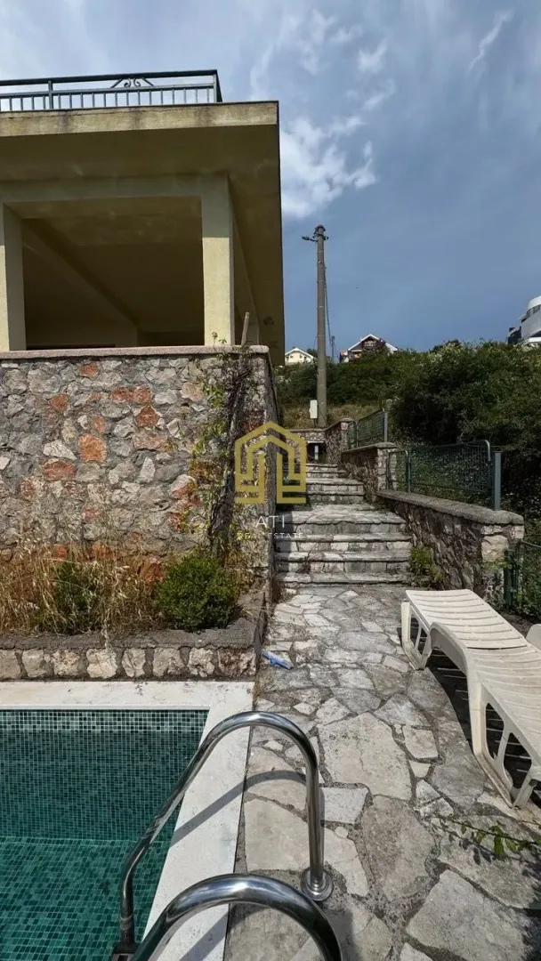 Eksterijer kuće sa bazenom i kamenim stepeništem.
