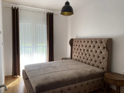 A bright bedroom featuring a large double bed with a tufted headboard. - image 10