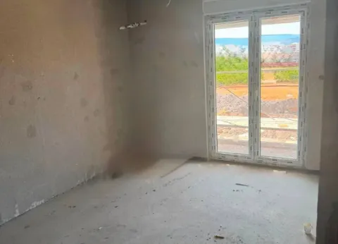 Unfinished room in grey phase with balcony doors. - image 3