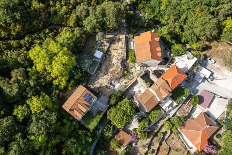 Pogled iz vazduha na kuće i imanje okruženo zelenilom. - image 17