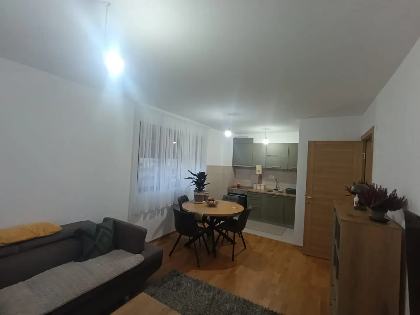 Dnevni boravak sa trpezarijom i kuhinjom u pozadini.