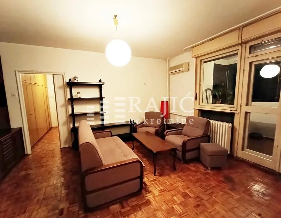 Living room with a seating set and parquet flooring.