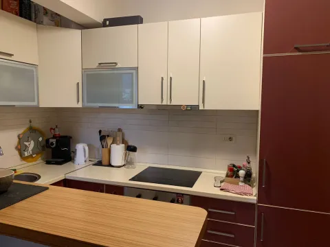 Modern kitchen with white upper cabinets and a countertop with a built-in cooktop. - image 3