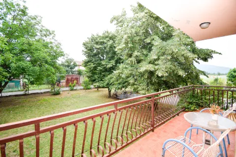 Balcony with seating furniture and a view of the green yard. - image 9