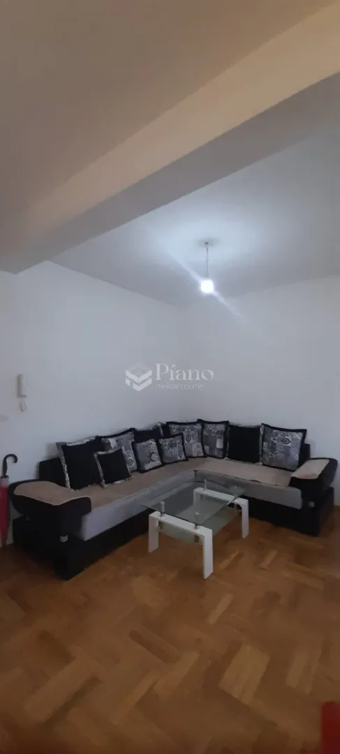 Dnevna soba sa ugaonom garniturom i stočićem.