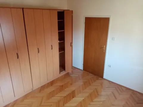 Bright empty room with a large wooden wardrobe and parquet flooring. - image 20