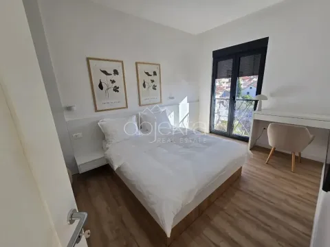 Svjetla spavaća soba sa bračnim krevetom, radnim stolom i balkonskim vratima. - image 7