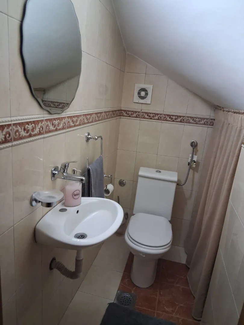 Manje kupatilo sa umivaonikom, wc šoljom i ogledalom.