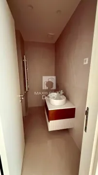 View of a modern bathroom with a washbasin and neutral-toned tiles. - image 8