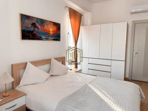 Furnished bedroom with a double bed, white wardrobe, and a painting on the wall. - image 6
