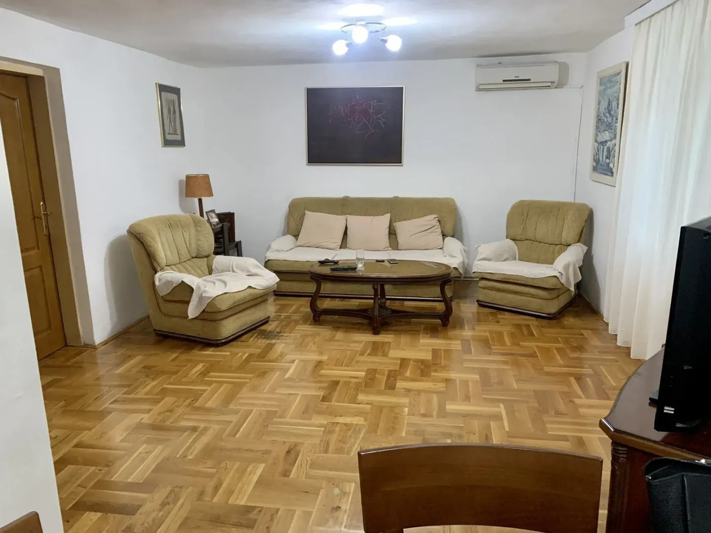 Living room featuring a seating set, a coffee table, and wooden parquet flooring.