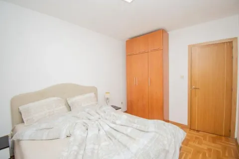 Bright bedroom with a double bed and a wooden wardrobe. - image 7