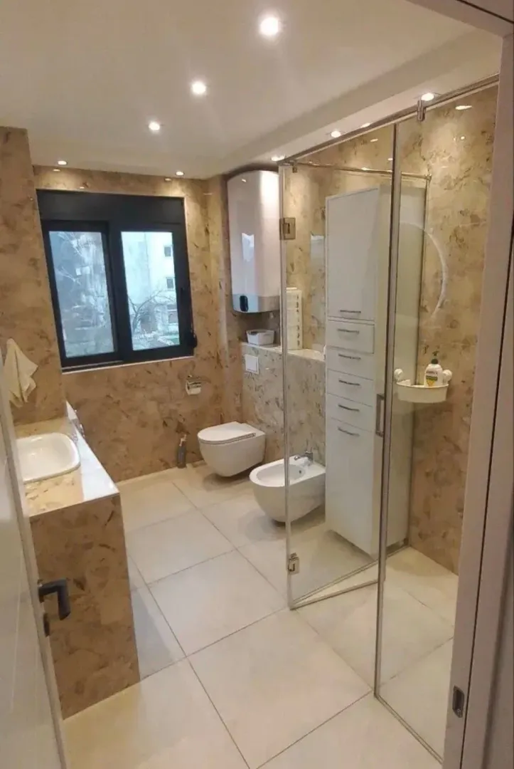 Modernly equipped bathroom with a shower cabin, sink, and sanitary facilities.