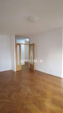 Empty room with hardwood parquet flooring and open double doors. - image 18