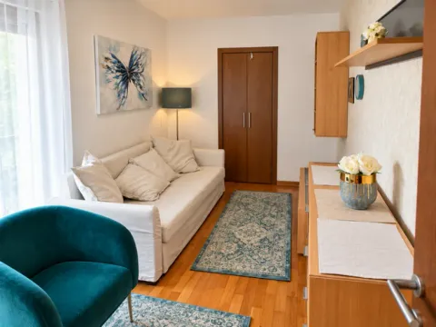 Living room with a sofa, armchair, and wooden furniture. - image 8