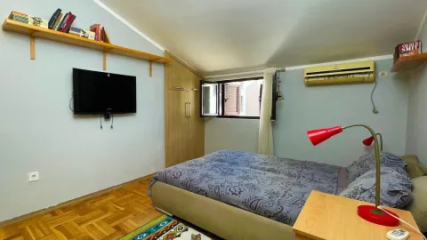 Furnished bedroom with a double bed, wardrobe, and TV. - image 7