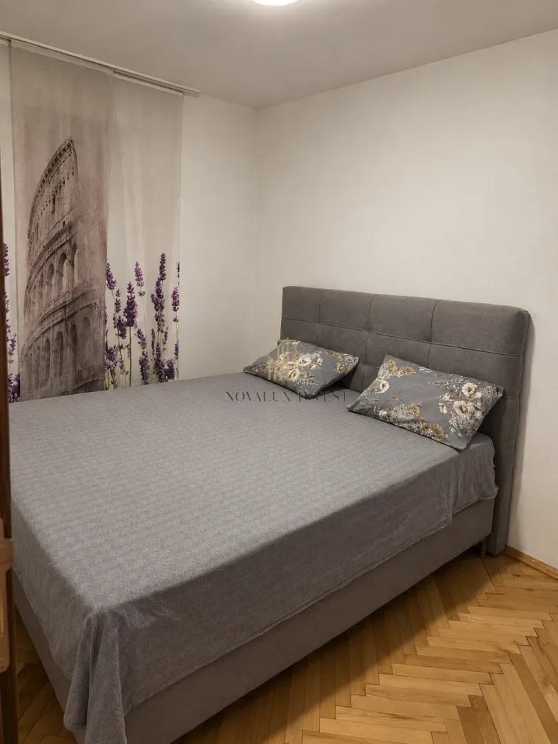 Bedroom with a double bed and parquet flooring.