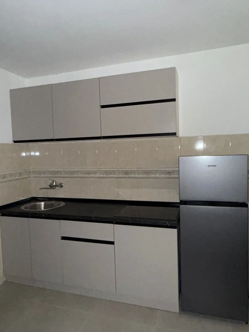 Small kitchen with cabinets and a refrigerator.