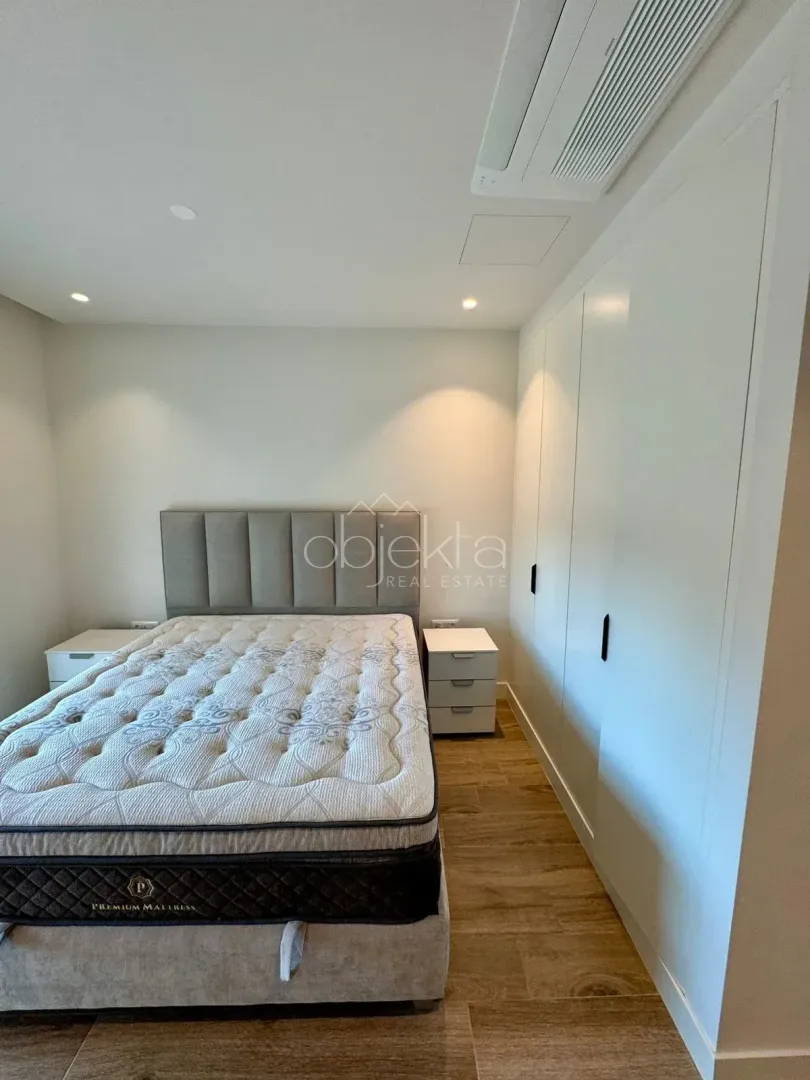 Bedroom with a double bed, nightstands, and a built-in wardrobe.