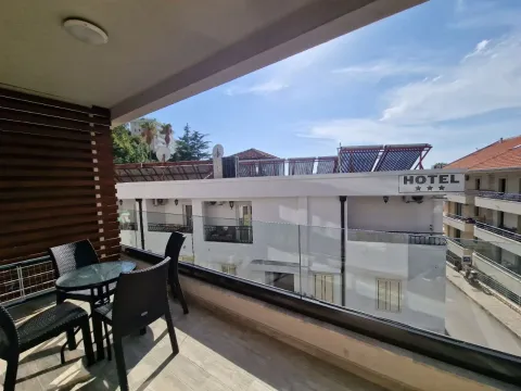 Furnished balcony with seating set and a view of surrounding buildings. - image 10