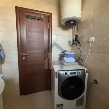 Bathroom with a washing machine, water heater, and wooden door. - image 16