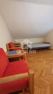 Potkrovlje opremljeno krevetom i drvenim foteljama sa parketom na podu. - image 15