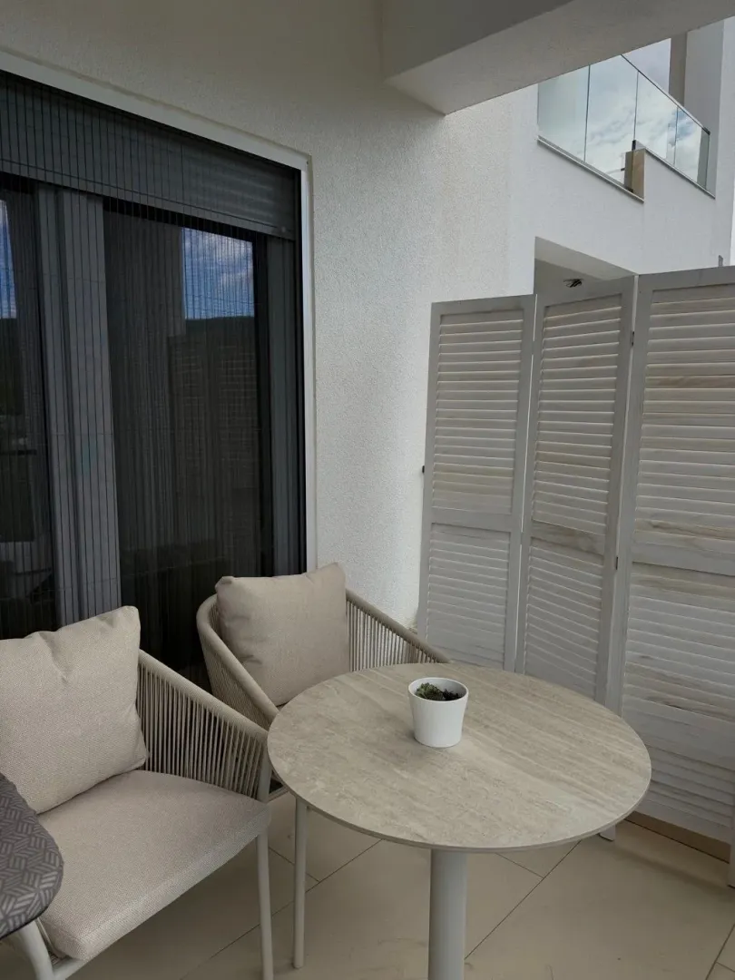 Furnished terrace with a table, chairs, and a screen divider.