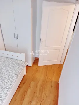 Manja spavaća soba sa krevetom i belim ormanom. - image 7