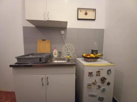 Small kitchen with a sink, cabinetry, and a refrigerator. - image 2