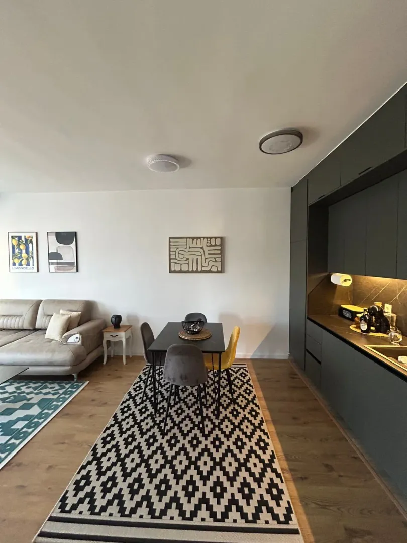 Modern open-plan space combining living room, dining area, and kitchen.