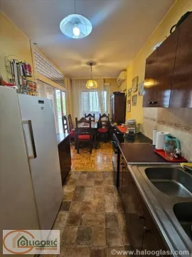 Long kitchen with a dining area at the far end of the room. - image 5