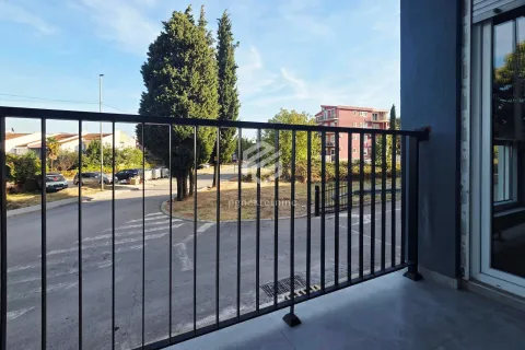 Pogled sa balkona na ulicu i zelenu površinu. - image 10