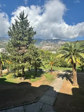 View from the property overlooking a landscaped courtyard with greenery and palm trees. - image 8