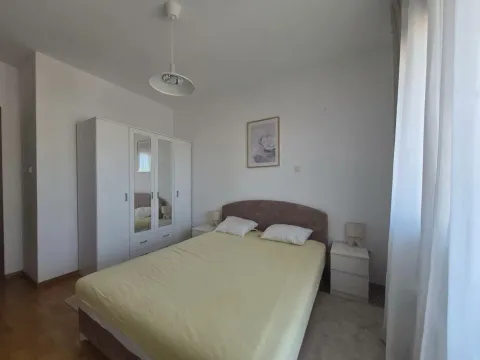 Bright bedroom with a double bed, white wardrobe, and bedside tables. - image 4